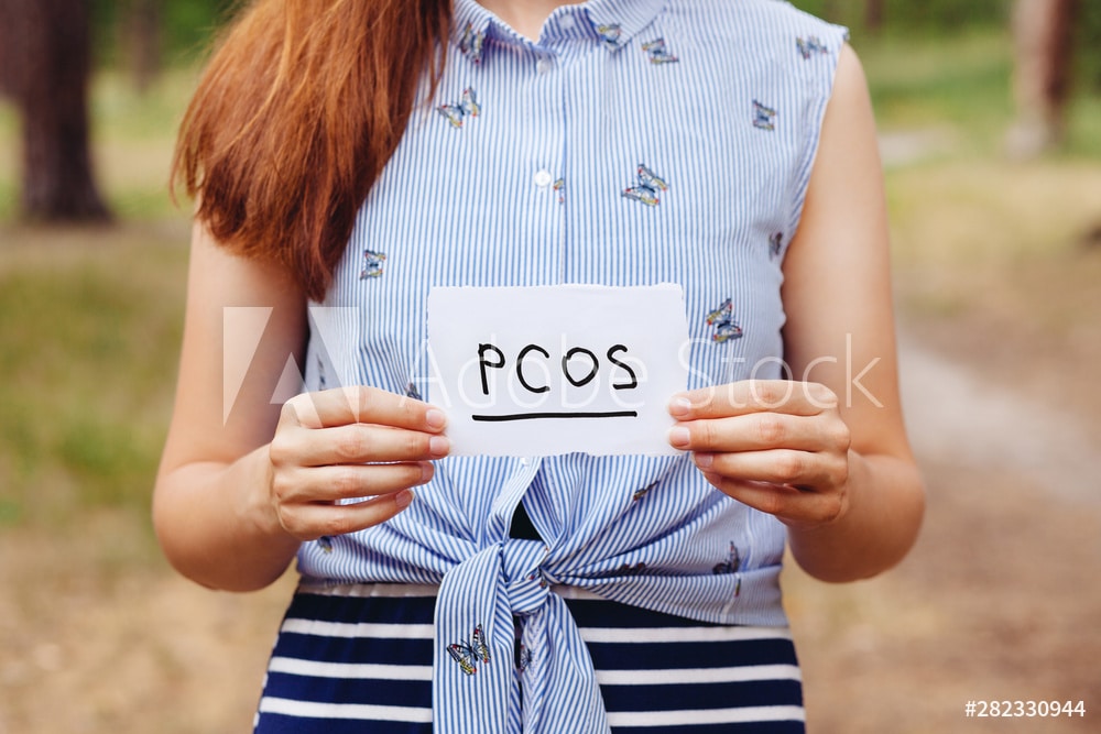 PCOS - Polycystic ovary syndrome, woman hormone sickness lettering on paper in womans hands